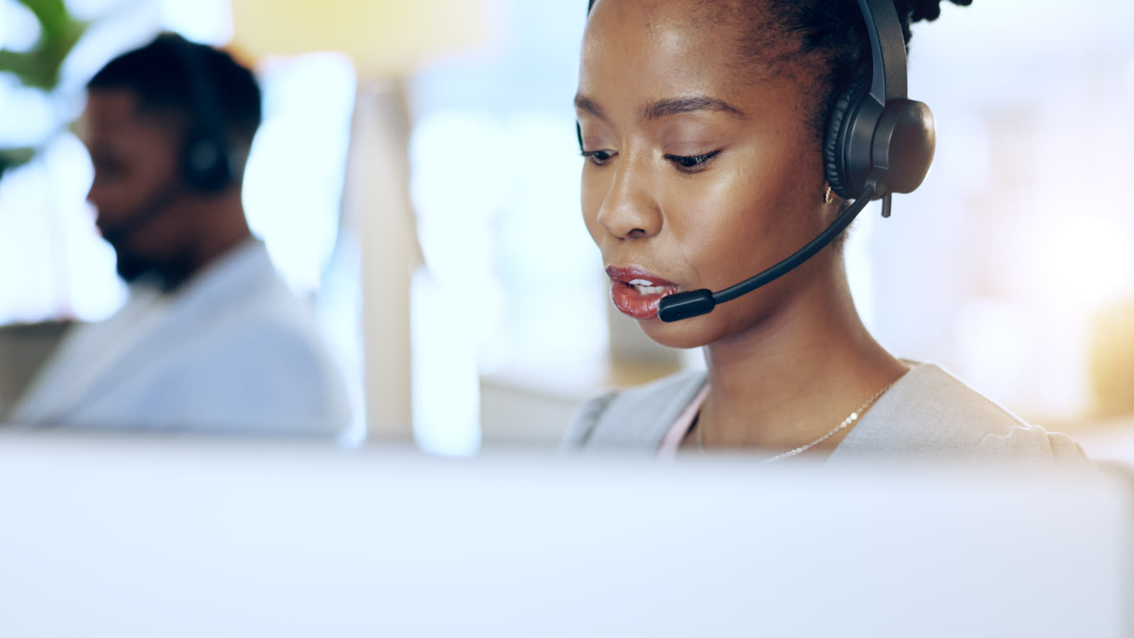 A customer support agent wearing a headset handles a customer enquiry at Adept's managed contact centre