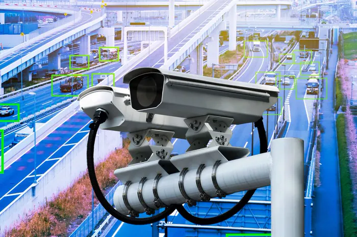 Traffic camera mounted above a motorway, with detected vehicles behind it