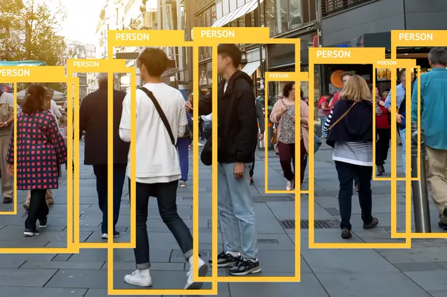 Pedestrians on a city street, each marked with a detection box