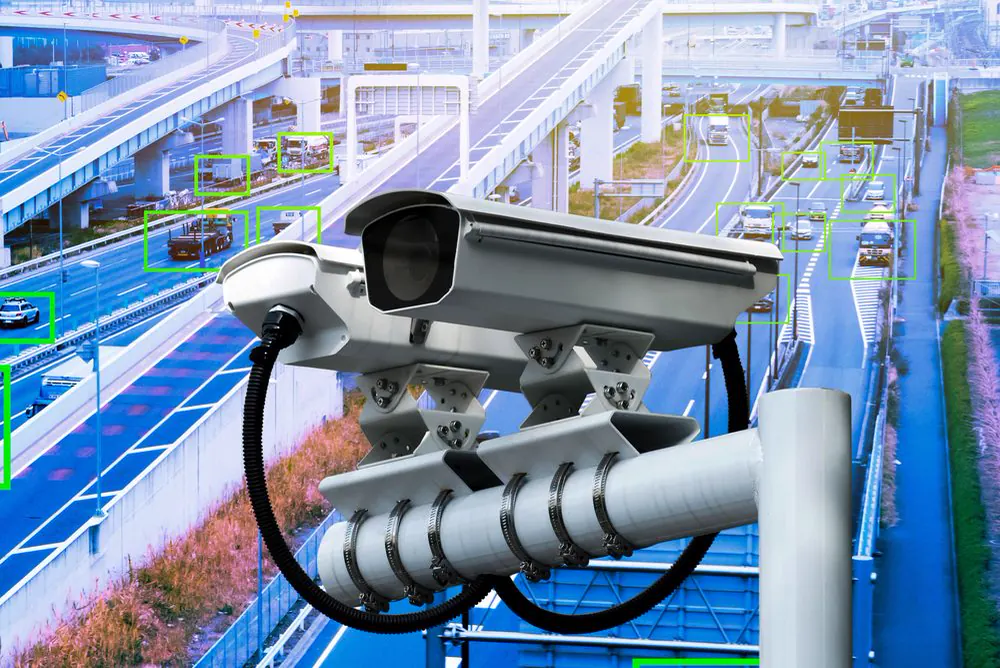 Traffic camera mounted above a motorway, with detected vehicles behind it
